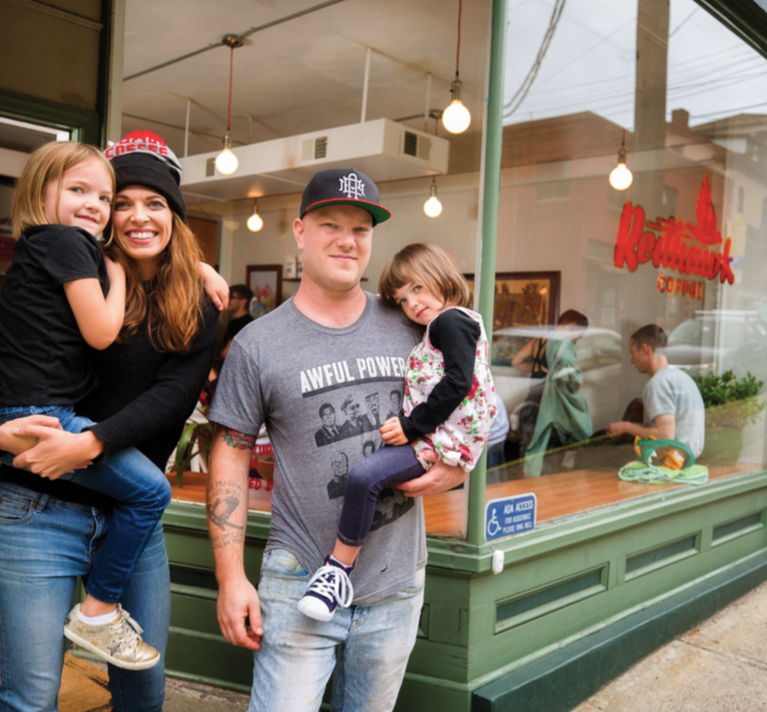 Mary and Braden with children smiling as a happy family in front of Redhawk Coffee in Oakland