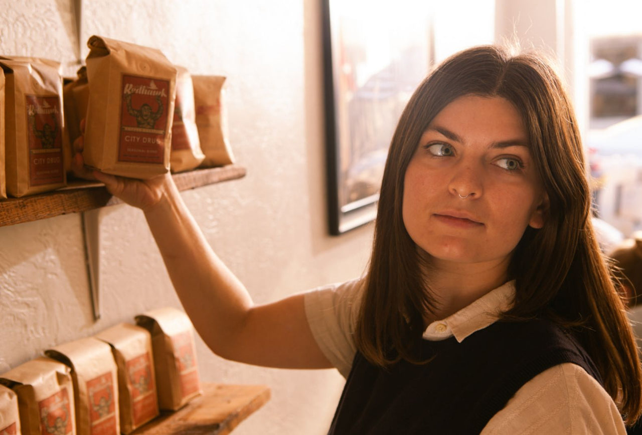 Young woman shopping for coffee at Redhawk Coffee Roasters.